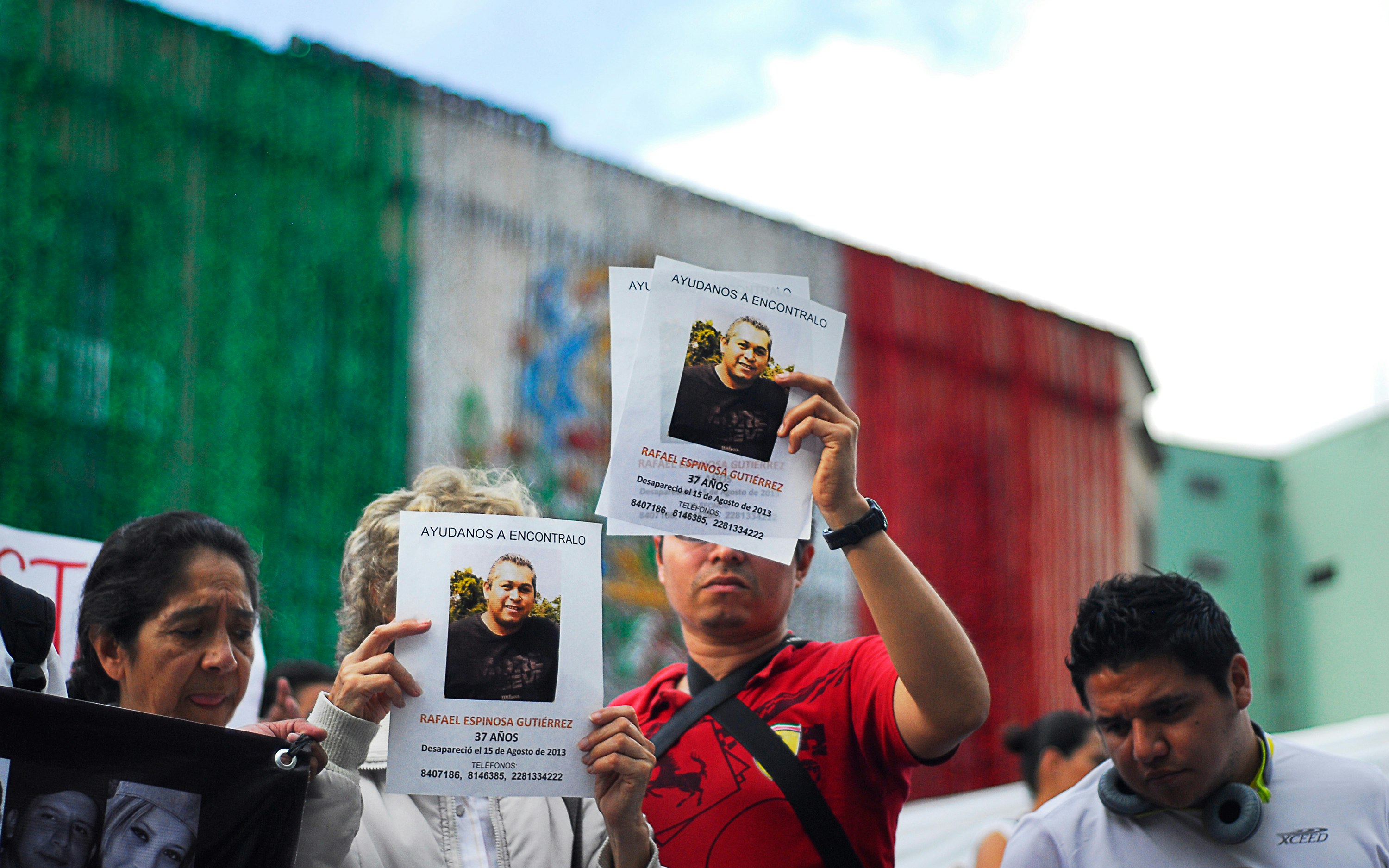 Personas sosteniendo carteles de personas desaparecidas