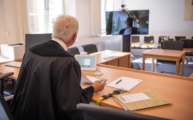 A German court talks to a lawyer through a camera during COVID-19.