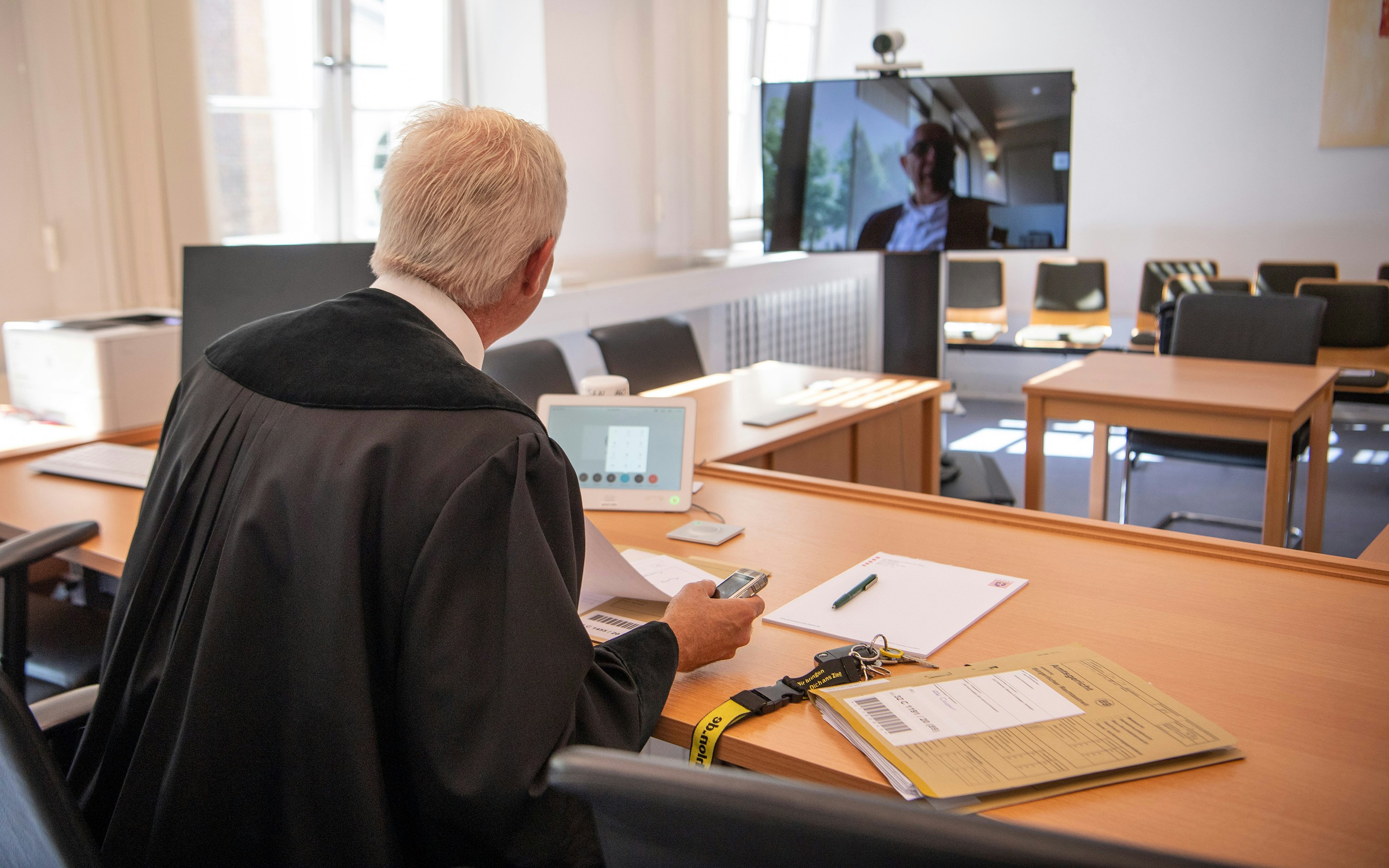 A German court talks to a lawyer through a camera during COVID-19.