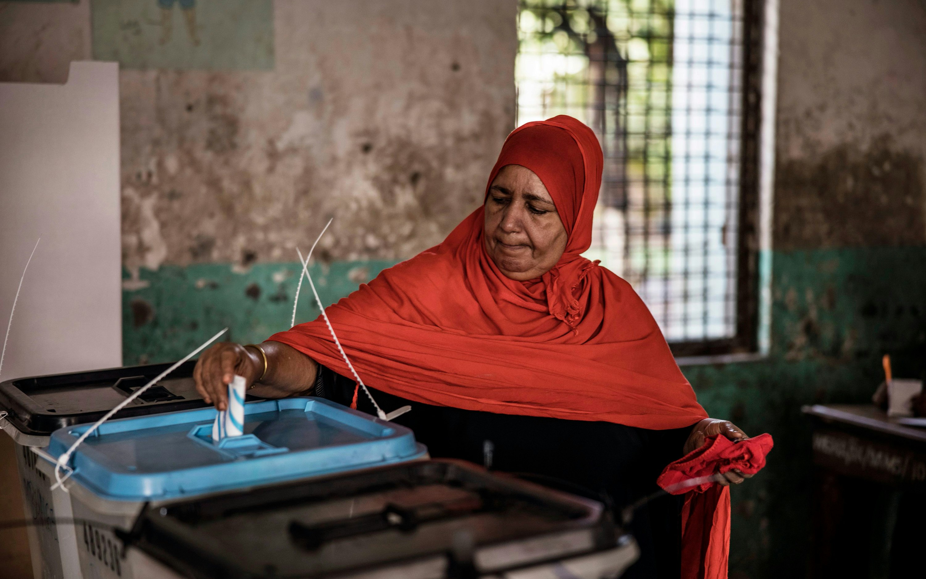 A woman casts her ballot at a polling station in Stone Town, Zanzibar