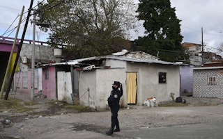 A female police officer walks in front of residential houses