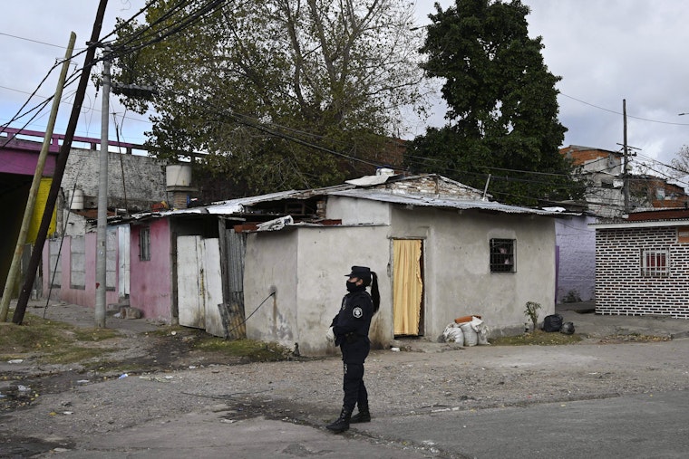 A female police officer walks in front of residential houses