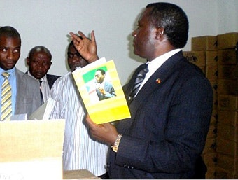 Man holding school notebook with a picture of President Teodoro Obiang on cover