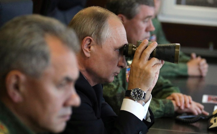 Russia’s President Vladimir Putin looks through binoculars