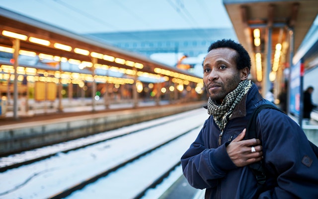 Mohamed Wa Baile photographed in a train station in Zurich, Switzerland, on January 19, 2016. Photo credit: © Manu Friederich A person stands at a train station.