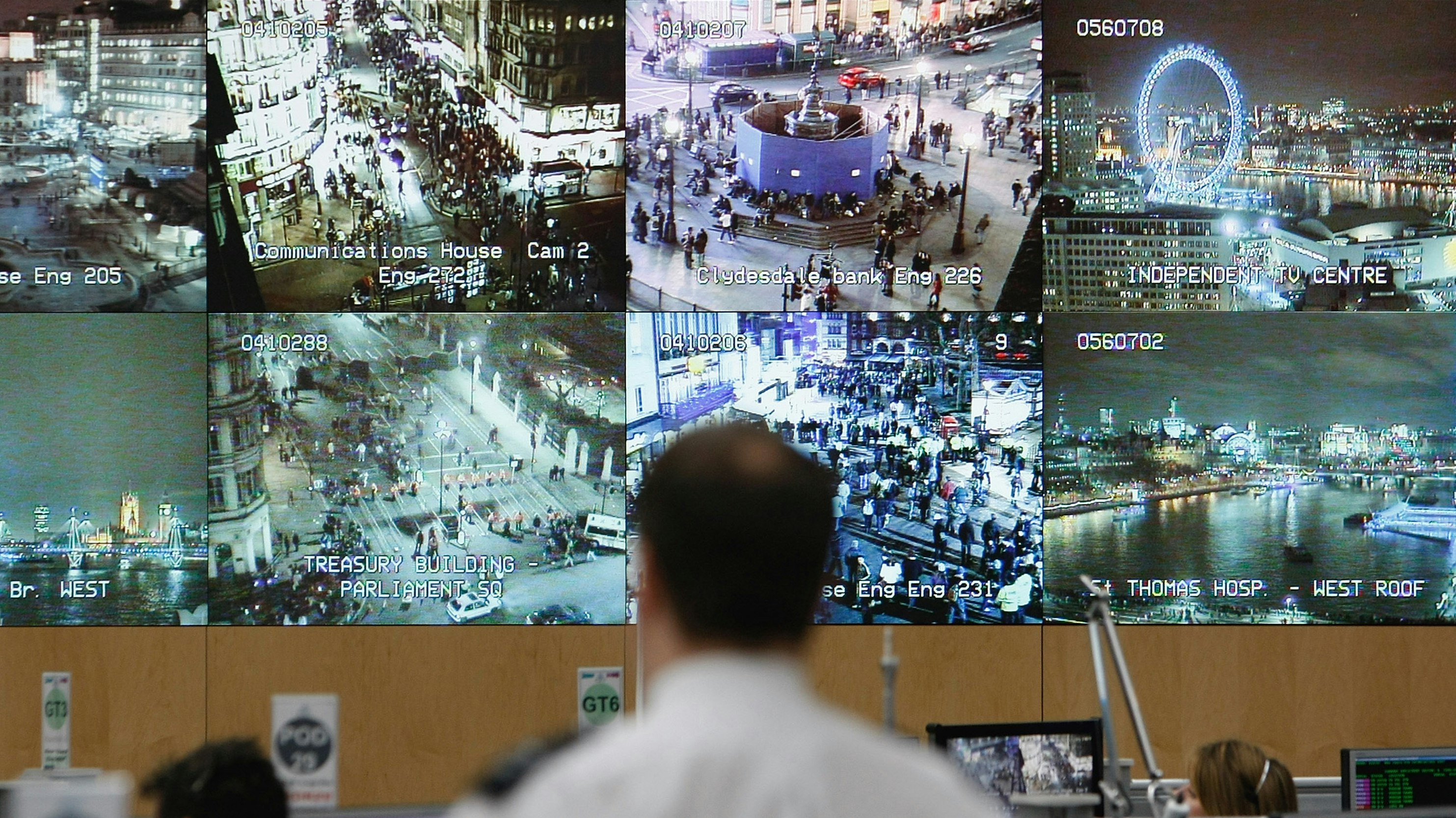 A bank of video monitors diplay footage at a police operations office.