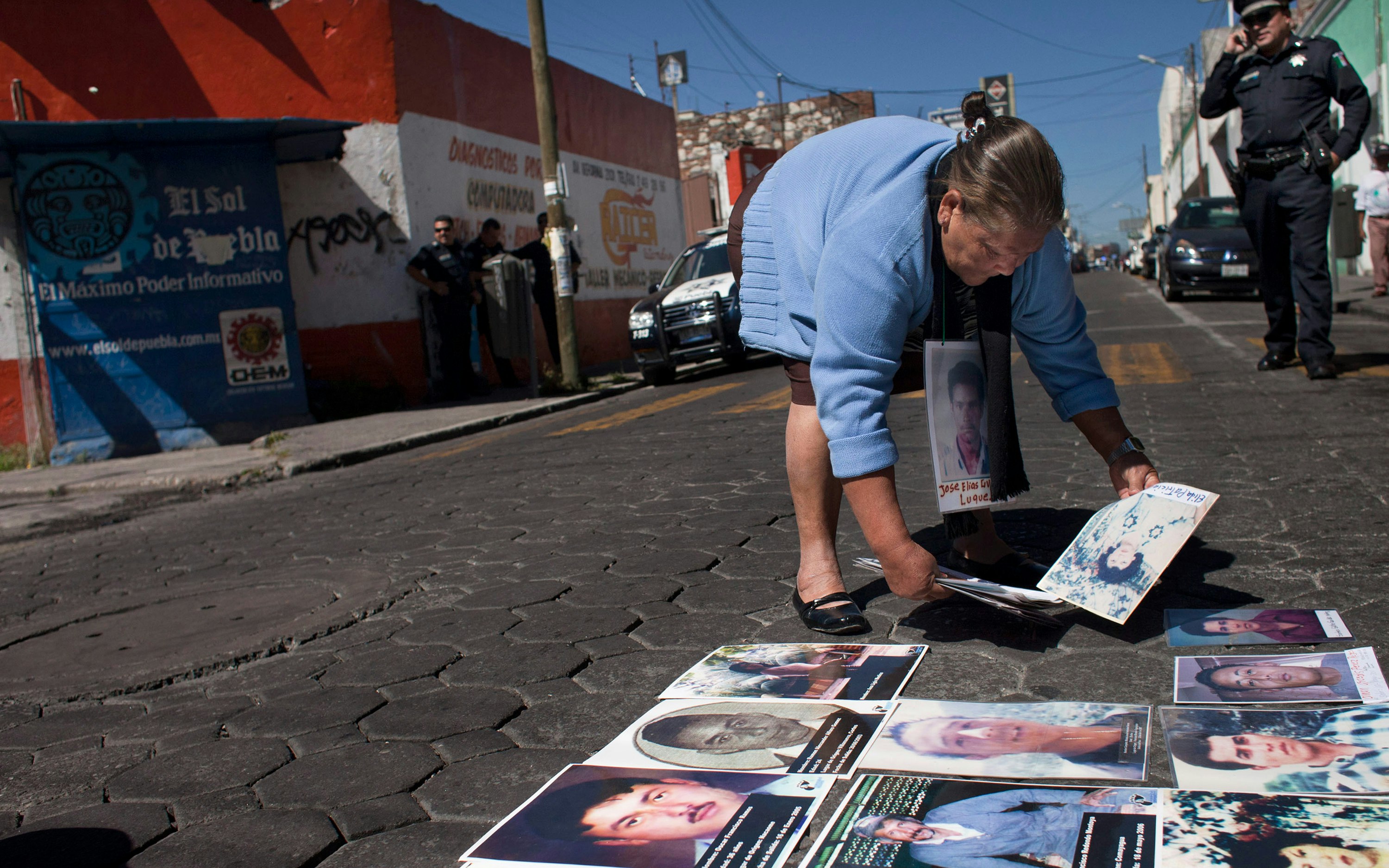 A woman placing photographs on a street