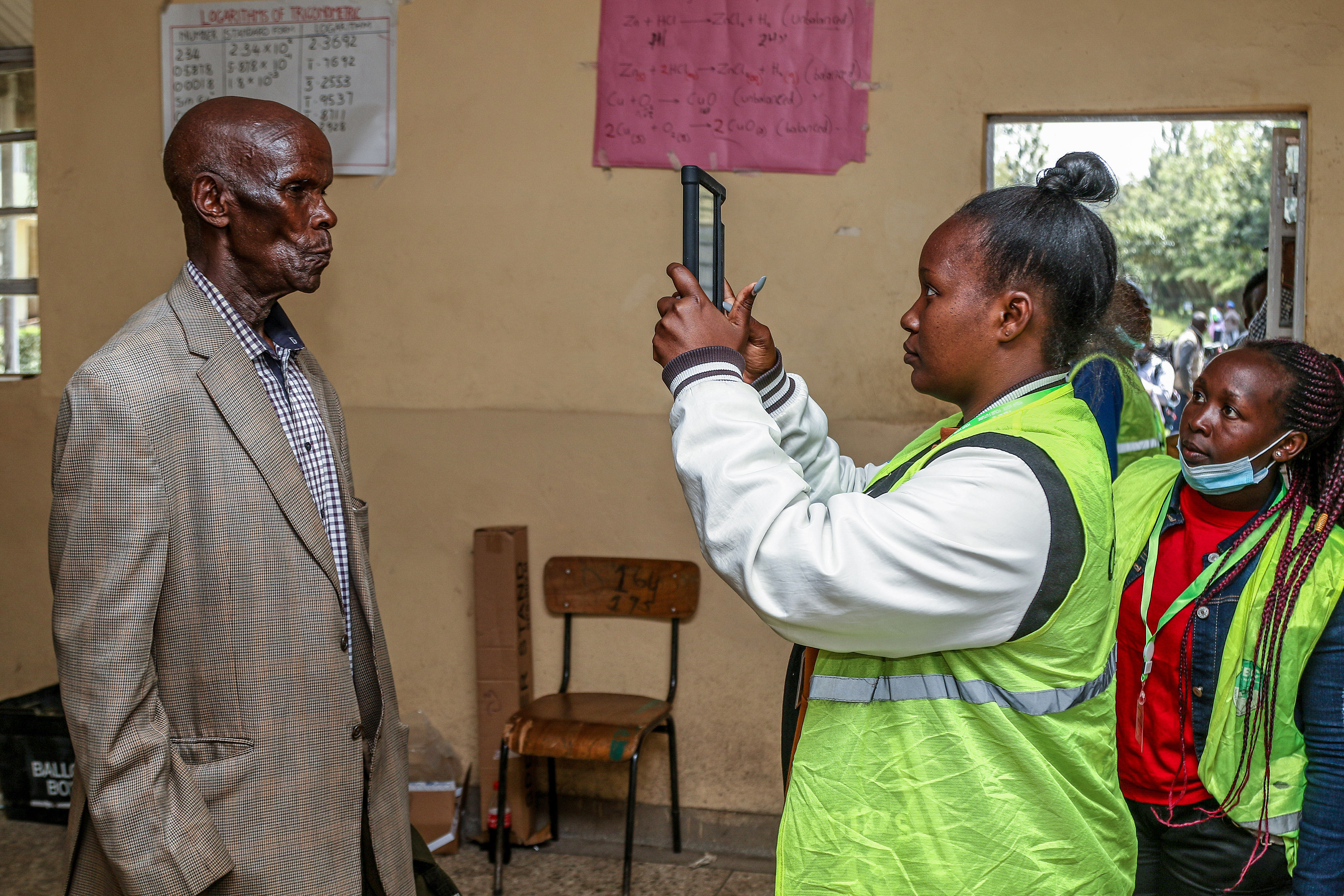 A woman photographs a man with an electronic tablet