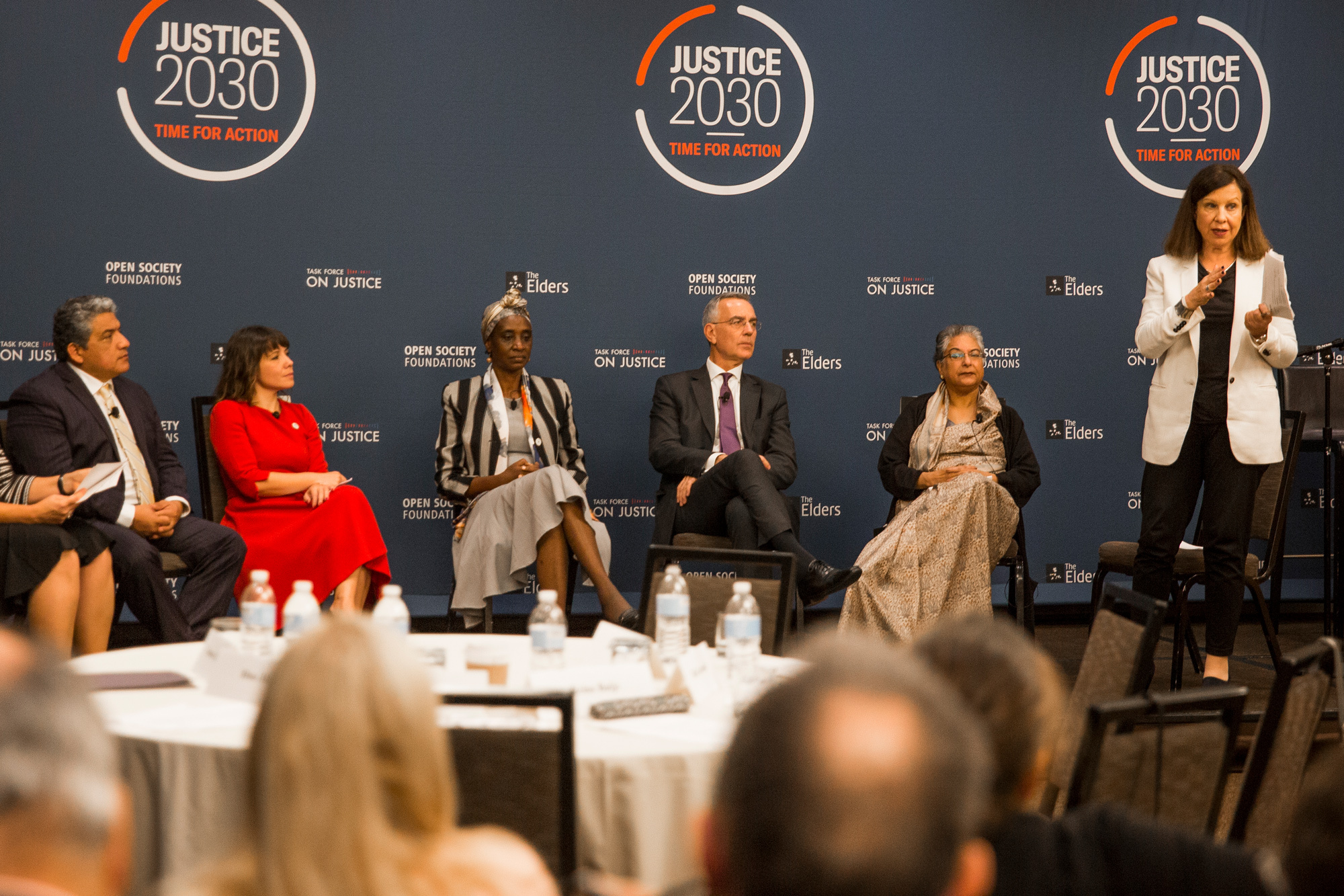 People speaking at a panel in front of a background that says "Justice 2030"
