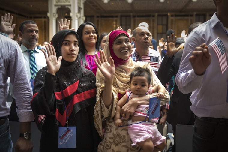 A woman holds her daughter during a naturalization ceremony.