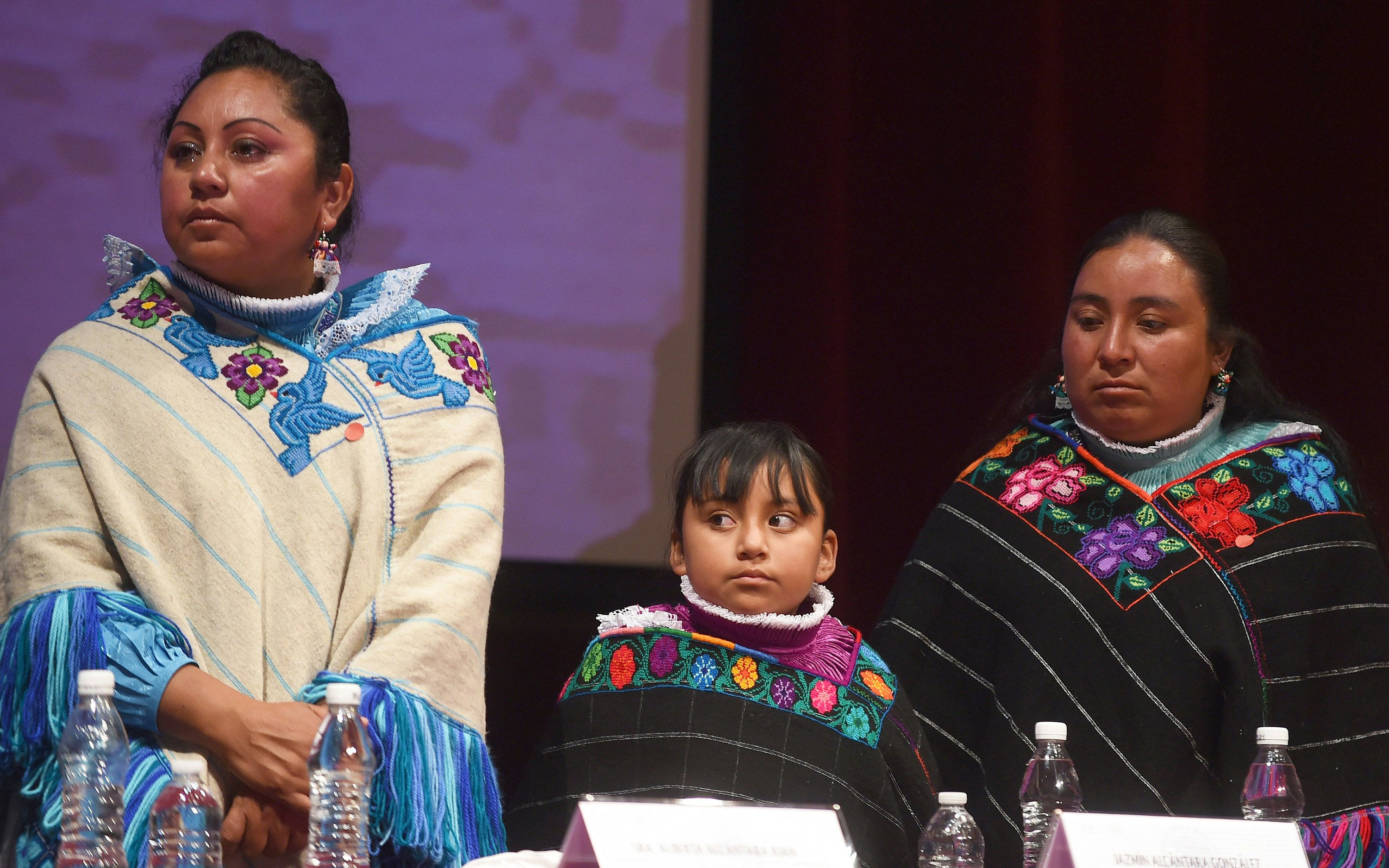 Two indigenous women and a child at a ceremony in Mexico City
