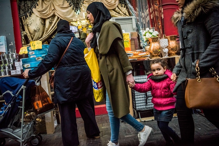Women walk down a street in Molenbeek, a district of Brussels, on March 26, 2016. Photo credit: © Daniel Berehulak/NYTimes/Redux Women walking past a shop