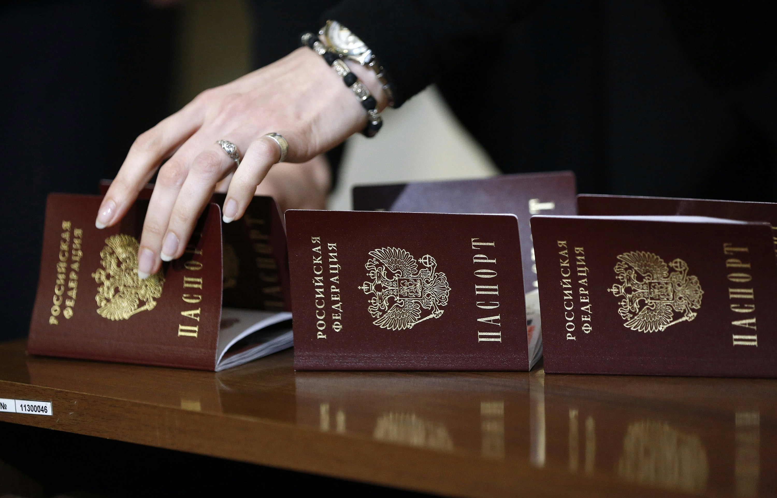 A woman&#039;s hand reaching toward a passport