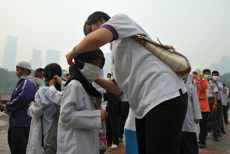 A group of students and a teacher under a haze filled sky